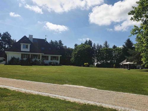 une maison sur un champ herbeux avec une route dans l'établissement Domaine idyllique Phamily House, à Senonches