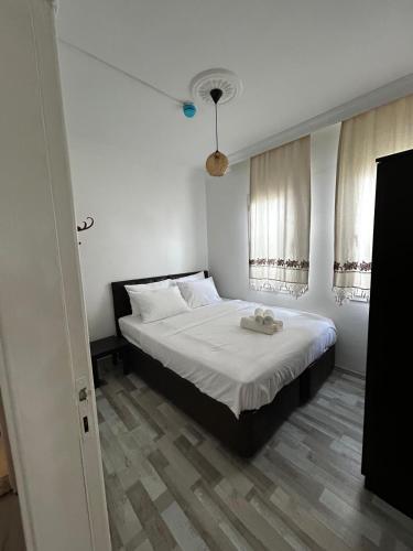 a bedroom with a bed with white sheets and a window at Çağlar my hause apart otel in Turgutreis