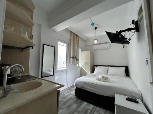 a hotel room with a bed and a sink at Çağlar my hause apart otel in Turgutreis