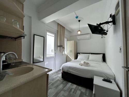 a bedroom with a bed and a sink in it at Çağlar my hause apart otel in Turgutreis