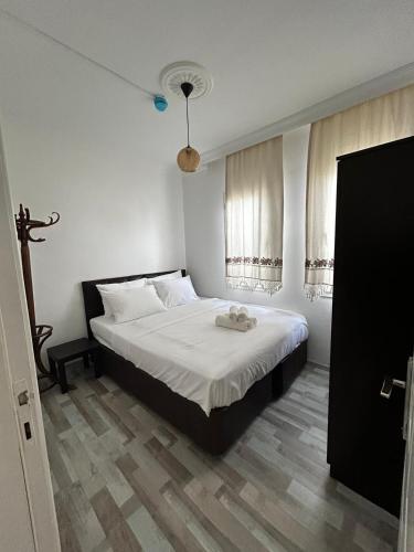 a bedroom with a large bed with white sheets at Çağlar my hause apart otel in Turgutreis