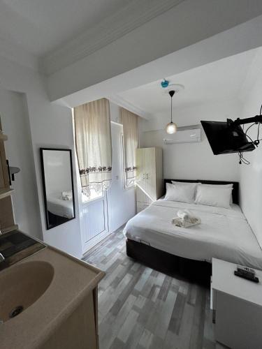 a bedroom with a bed and a bathroom with a sink at Çağlar my hause apart otel in Turgutreis