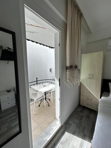 a bedroom with a door open to a room with a table at Çağlar my hause apart otel in Turgutreis