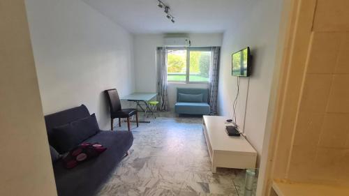 un salon avec un canapé et une table dans l'établissement Petit studio promenade des Anglais, à Nice
