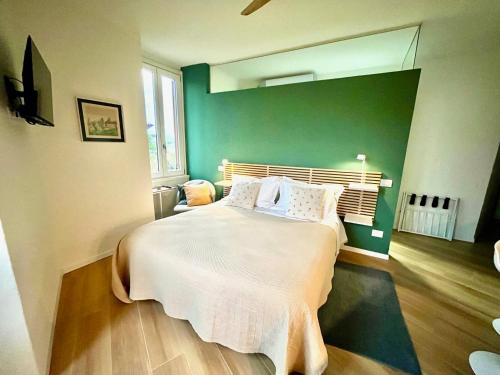 a bedroom with a large bed with a green wall at Una finestra sul parco in Bergamo