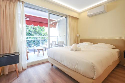 une chambre avec un grand lit et une grande fenêtre dans l'établissement 5 mn à pieds de Monaco - Sublime studio - DB, à Les Moneghetti