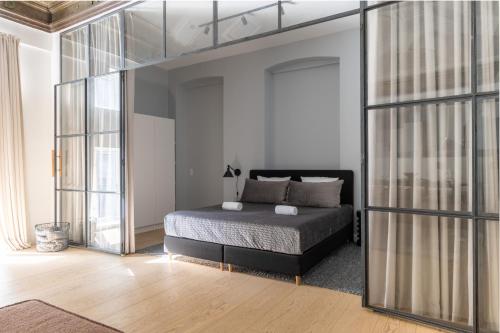 a bedroom with a bed and a large glass wall at Unique 3 Bedroom Apartment in Vibrant Frederiksberg in Copenhagen