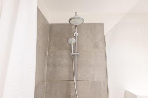 a shower in a bathroom next to a wall at Unique 3 Bedroom Apartment in Vibrant Frederiksberg in Copenhagen