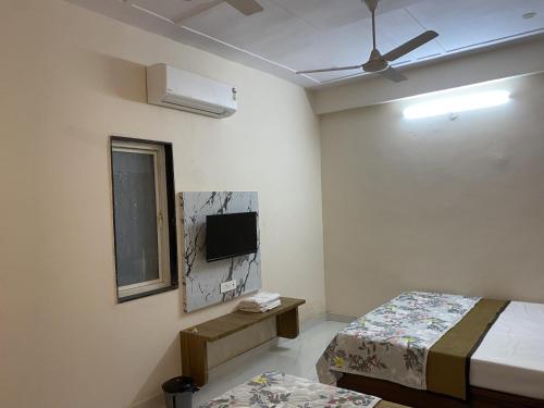 a room with two beds and a television in it at Hotel Banshi Wala - Best Hotel in Khatu Shyam ji Near Khatu shyam ji Tample in Khātu