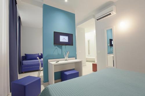 1 dormitorio con 1 cama y TV en la pared en Hotel Agrigento Home, en Agrigento