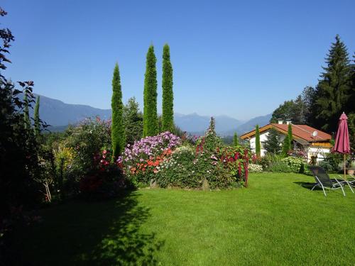 a garden with flowers and trees and a house at Landhaus Bonaventura in Millstatt
