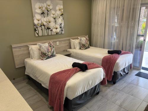 a bedroom with two beds with blankets on them at Lodge Azure in Port Edward