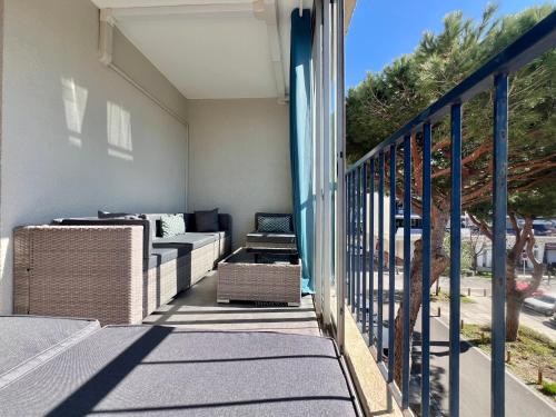 un balcon avec un canapé et des chaises sur une maison dans l'établissement Grand appartement mer et commerces à pied, à La Grande Motte
