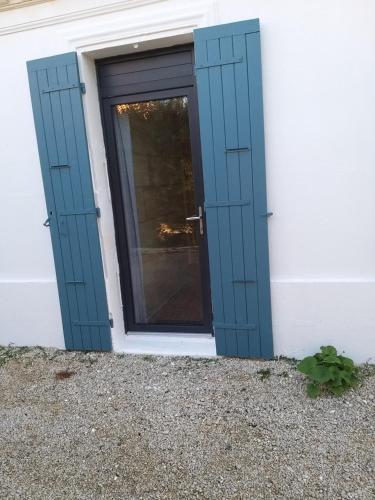 une porte avec une fenêtre sur le côté du bâtiment dans l'établissement Sucré salé, à Le Port-des-Barques