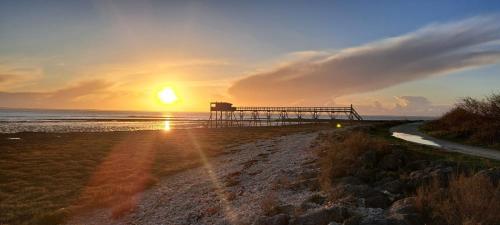 - une jetée sur la plage avec un coucher de soleil dans l'établissement Sucré salé, à Le Port-des-Barques