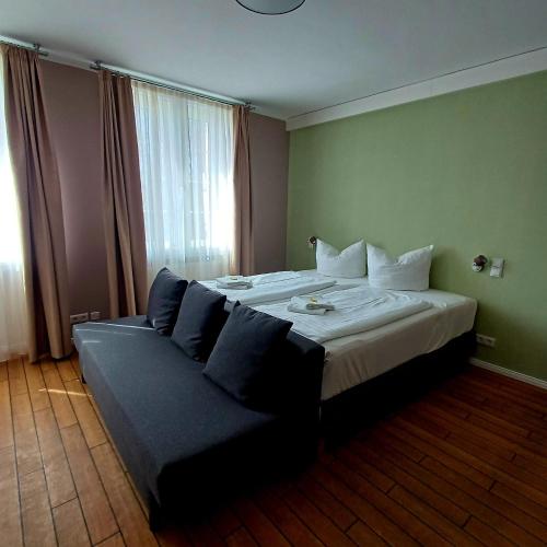 a hotel room with two beds and a couch at Land-Gut-Hotel- Weisser Schwan in Zossen