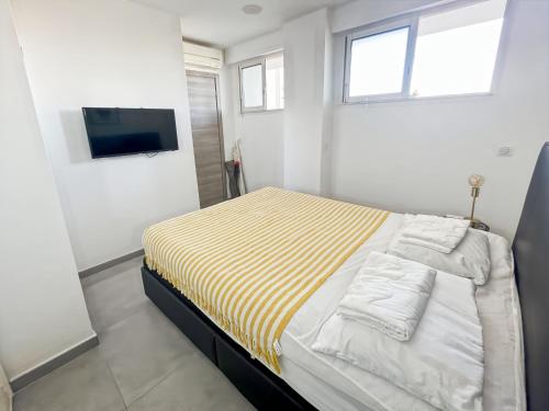 - une chambre dotée d'un lit avec une couverture rayée jaune et blanche dans l'établissement Serenity Cannes Cozy One-Bedroom, à Cannes