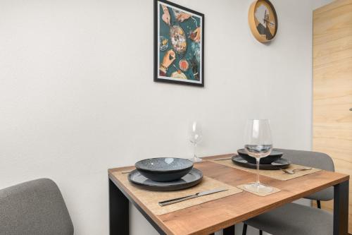 a wooden table with two glasses and a plate on it at EDMUNDs - Bergblick im Wanderparadies, Nintendo Switch, Parkplatz in Bad Berleburg