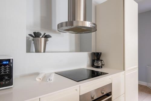 a kitchen with white counters and a stove top oven at Unique 3 Bedroom Apartment in Vibrant Frederiksberg in Copenhagen