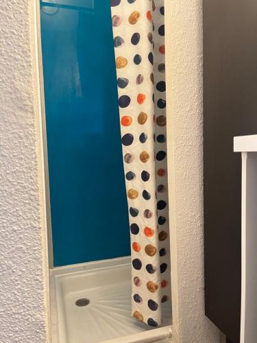 - un rideau de douche dans l'angle de la salle de bains dans l'établissement CapNat - Village Naturiste - Port Nature - Le Bisou, au Cap d'Agde