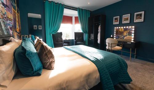 a bedroom with a large bed with blue walls at St Hildas Complex in Hinderwell