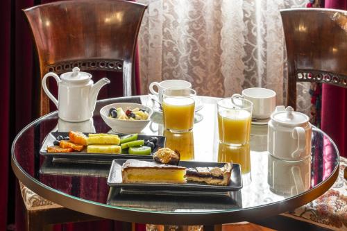 una mesa con una bandeja de comida y vasos de zumo de naranja en Hotel Casa Nicolò Priuli, en Venecia