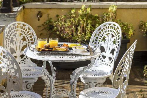 Una mesa blanca y sillas con una bandeja de comida. en Hotel Casa Nicolò Priuli, en Venecia