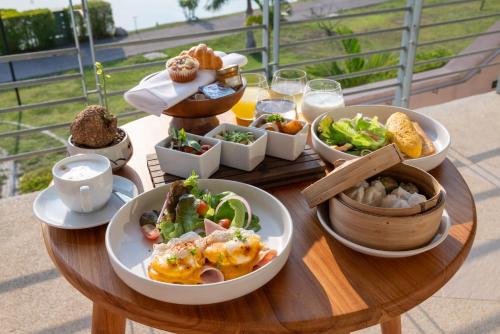 a wooden table with bowls of food on it at The Kaset, Hua Hin in Hua Hin