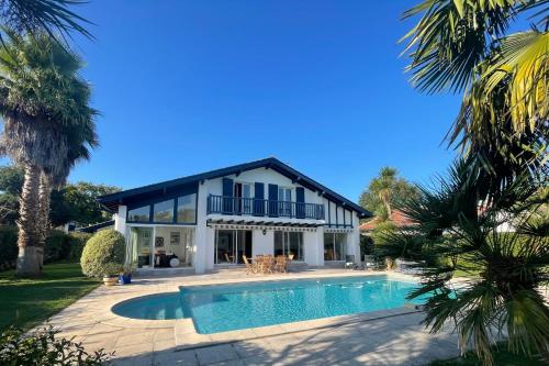 eine Villa mit Swimmingpool und ein Haus in der Unterkunft Villa on the Makila golf course near Biarritz in Bassussarry