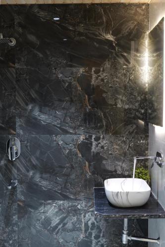 bagno con parete in pietra nera e lavandino di Hotel Mahadev Villa Elite a Jaipur