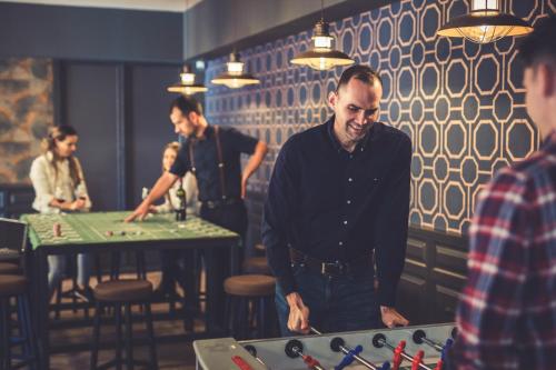 a man standing in front of a table in a restaurant at Hotel Cabernet in Villánykövesd