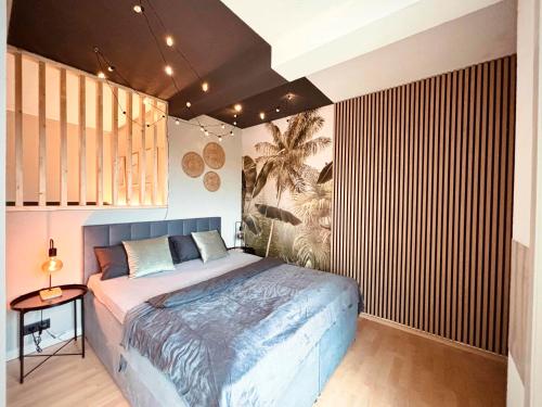 a bedroom with a large bed and a wooden wall at Apartment Kokorey in Halstenbek