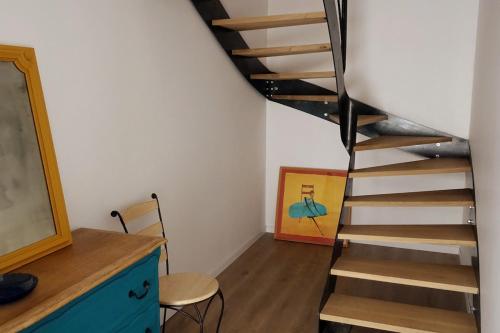 a spiral staircase in a room with a table and chairs at moulin de vasiliere in Salles-Courbatiès