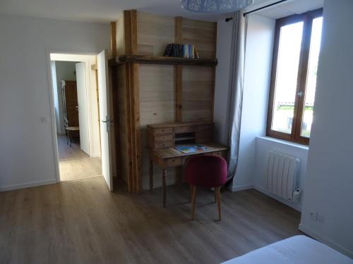 a room with a desk and a chair and a window at moulin de vasiliere in Salles-Courbatiès