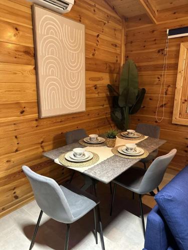 a table and chairs in a room with wooden walls at أكواخ البرنسيسة in Jeddah