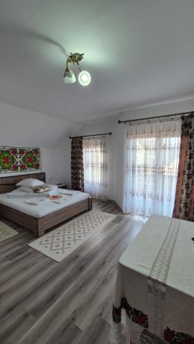 a bedroom with two beds and two windows at Casa Pintea de Sub Coastă in Breb
