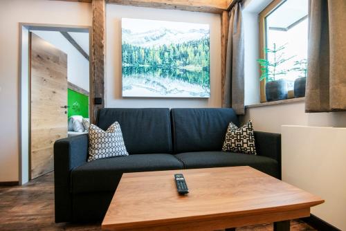 a living room with a couch and a table at AlpinSpa zur Post - Bergbahn im Sommer 2025 inklusive in Bad Gastein