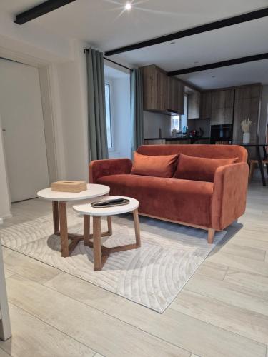 a living room with a couch and two tables at Campagne - appartement rénové avec 2 chambres in Estavayer-le-Lac