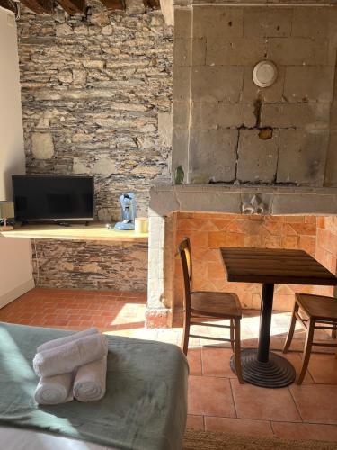Cette chambre dispose d'une table et d'un bureau avec une télévision. dans l'établissement Studio CENTRE VILLE ANGERS 1ER ETAGE - 2 PERSONNES, à Angers