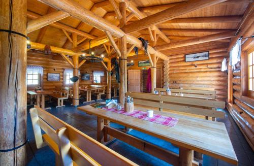 a dining room with wooden benches in a cabin at Ranč pod Ostrou Skalou in Stratená