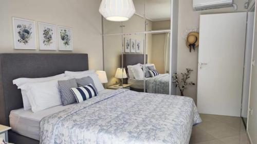 a bedroom with a large bed and a mirror at Overlooking the blue sea in Rafina