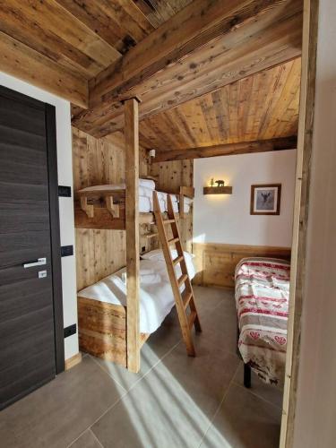 2 letti a castello in una camera con soffitti in legno di Dolom Love Larice PadolaDolomiti a Padola