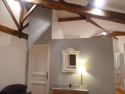 une chambre avec une table et une lampe sur un mur dans l'établissement La Magie Des Rêves, à Montréjeau