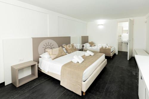 2 łóżka w sypialni z białymi ścianami w obiekcie Ungaretti Resort w mieście Porto Cesareo