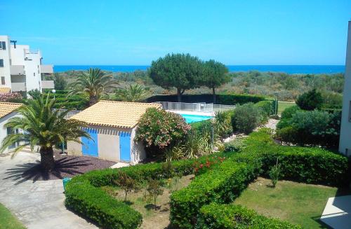 - une vue aérienne sur une maison avec un jardin et une piscine dans l'établissement Studio cabine avec accès direct piscine collective et plage - 4FR503, à Saint-Cyprien