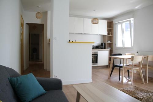 un salon et une cuisine avec un canapé et une table dans l'établissement Saint-Patern - centre-ville - Wifi, à Vannes