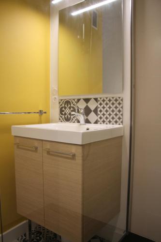une salle de bain avec un lavabo et un miroir dans l'établissement Saint-Patern - centre-ville - Wifi, à Vannes