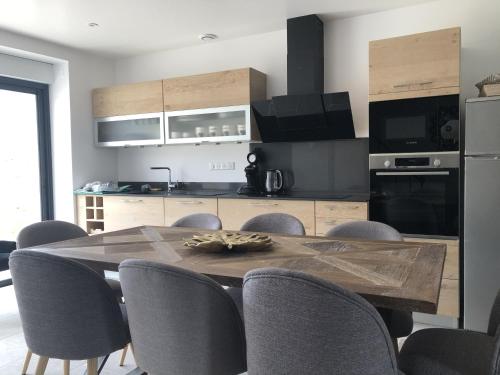 a kitchen with a wooden table with chairs and a kitchen with a refrigerator at Maison de Pauline, Chablis Vineyard in Préhy