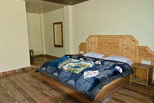 a bedroom with a large bed with a wooden headboard at Devcasa By Nomadic Den Manali in Manāli