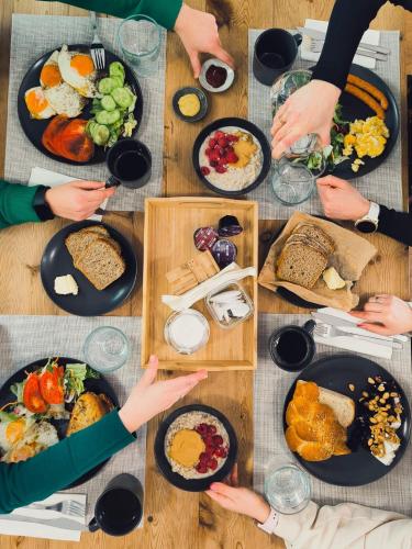 een groep mensen die rond een tafel zitten met eten bij Trevi Apartments Tychy in Tychy